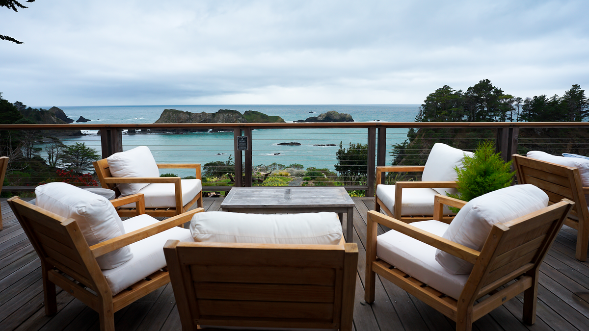 Teak lounge chairs on the ocean-view deck at Harbor House Inn overlooking the sea stacks of Elk, Mendocino coast