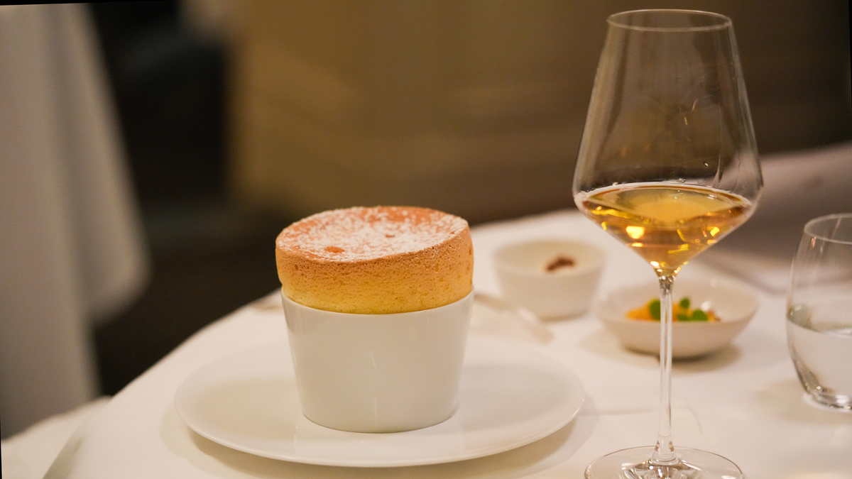 A golden Grand Marnier soufflé with a glass of sweet white wine at La Mère Brazier, Lyon