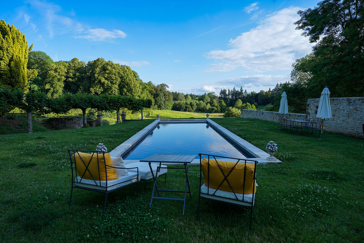 Long lap pool with lounge chairs in the walled garden lawn at Château de la Barre, Loire Valley