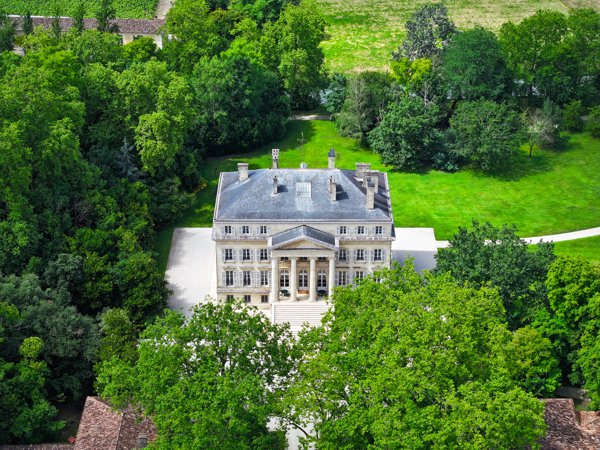 Aerial view of the neoclassical Château Margaux nestled in trees and parkland, Bordeaux