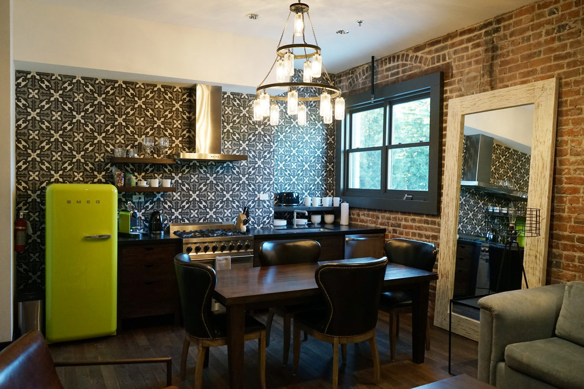 Loft kitchen with a lime-green retro fridge, patterned tile and exposed brick at SLO Brew Lofts, San Luis Obispo