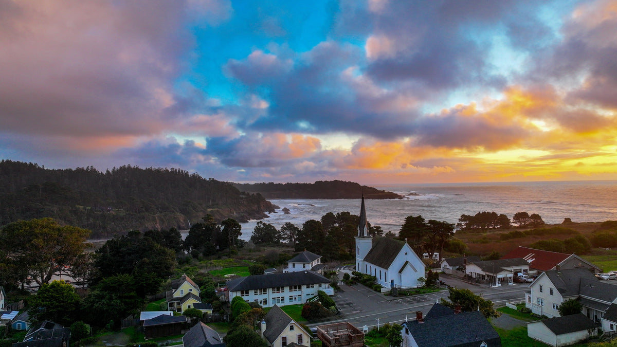 Sunset over Mendocino village, its white church and the rugged headlands from the air